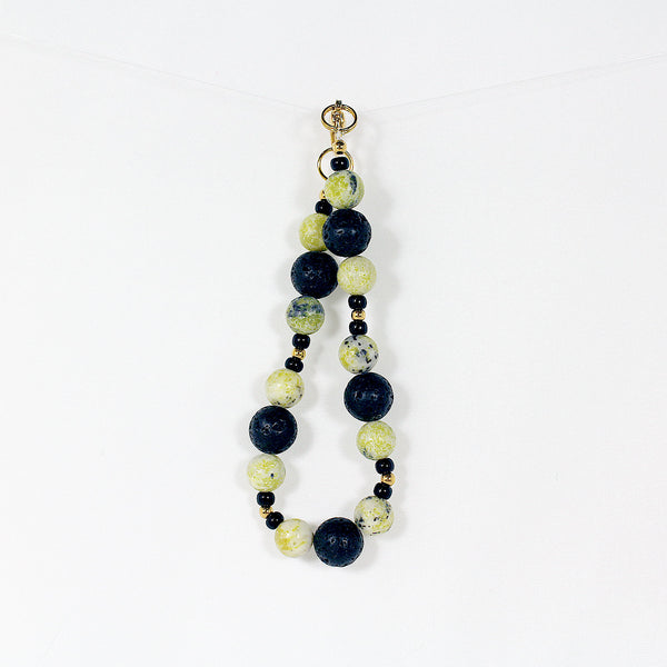 Bracelet featuring yellow kiwi jade and black lava beads