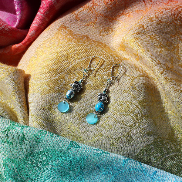 Earrings with silver bunny charms and turquoise-colored swirl beads and turquoise dangle shell chip bead