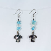 Earrings featuring sea turtles, faux pearls, turquoise-coloured chip beads, and silver trim