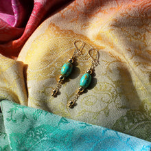 Earrings with oval-shaped turquoise beads with shimmery gold swirls